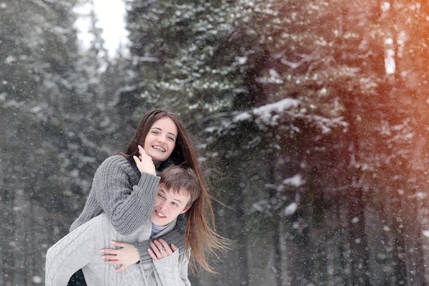 A loving couple on a winter walk. Man and woman on a date in the park in winter. Friends in winter park