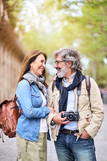 Loving elderly tourist couple looking at romantic outdoors in city smiling adult people traveling