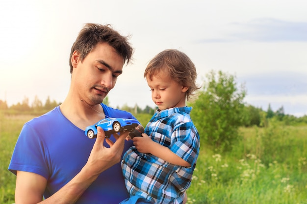 Loving father with his little son outdoors playing with a radio controlled toy car