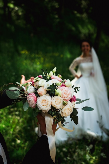 Loving groom with a wedding bouquet of flowers for a walk with the bride 2