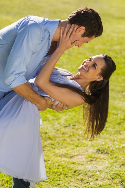 Loving and happy couple dancing in park