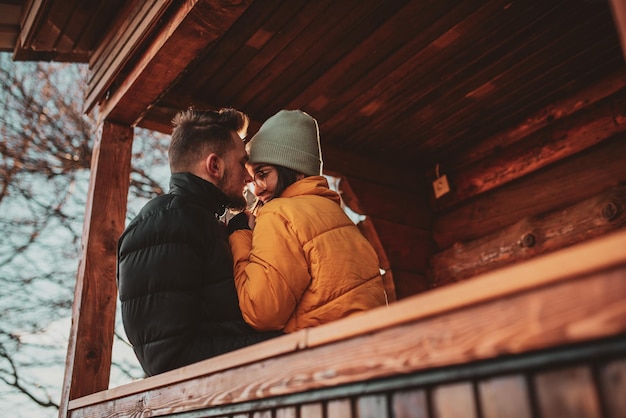 Loving man and woman standing in their cottage room balcony