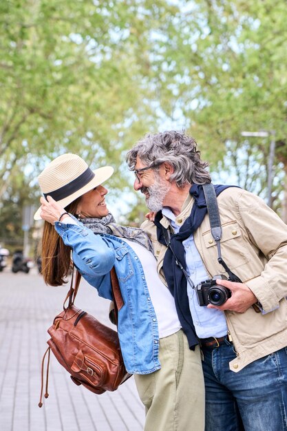 Photo loving mature retired couple hugging and looking at in romantic attitude springtime outdoors