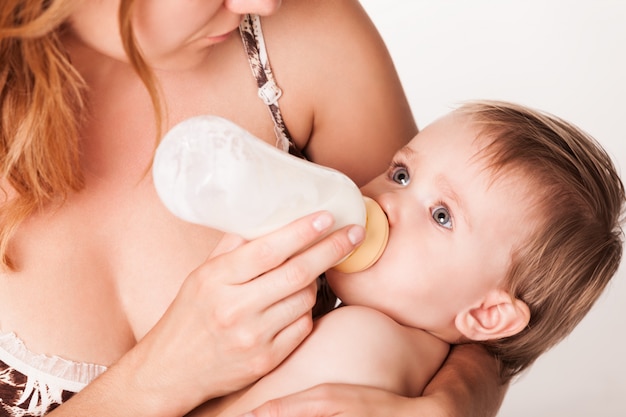 Loving mother bottle feeding baby.