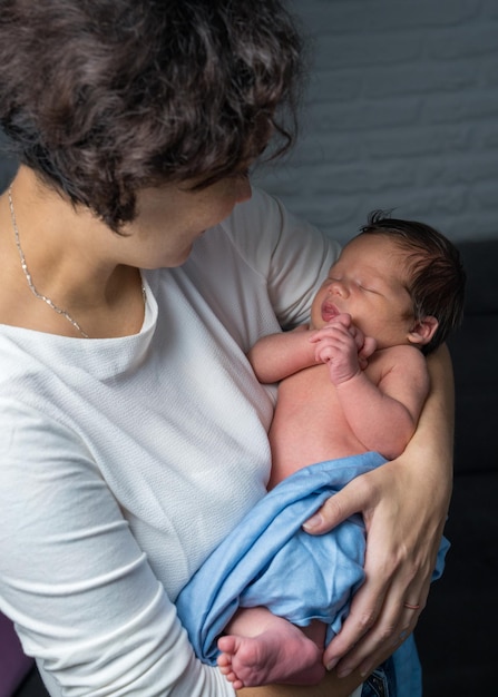 A loving mother takes care of her newborn baby a happy mother holds her baby in her arms