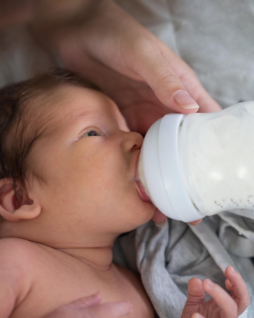 Loving mother takes care of her newborn baby Mom feeds her newborn baby with a bottle