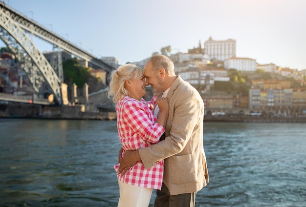 Loving senior spouses embracing during outdoor walk on promenade