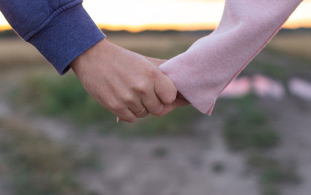 loving young couple holding hands. Hands of a girl and a guy close-up.