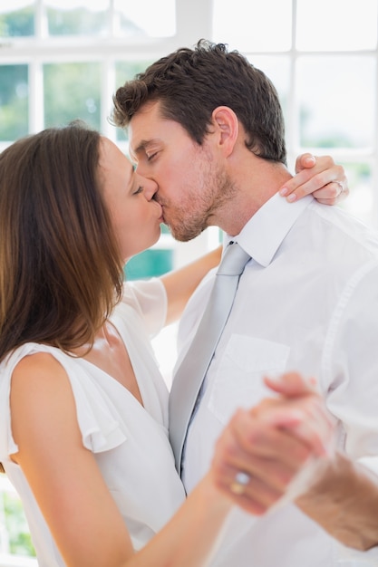 Loving young couple kissing at home