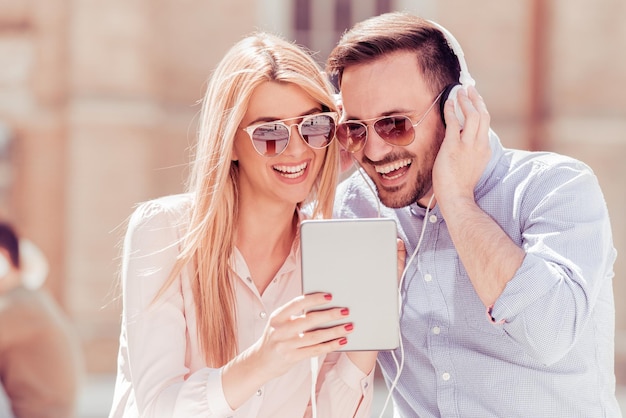 Loving young couple listening to music in city