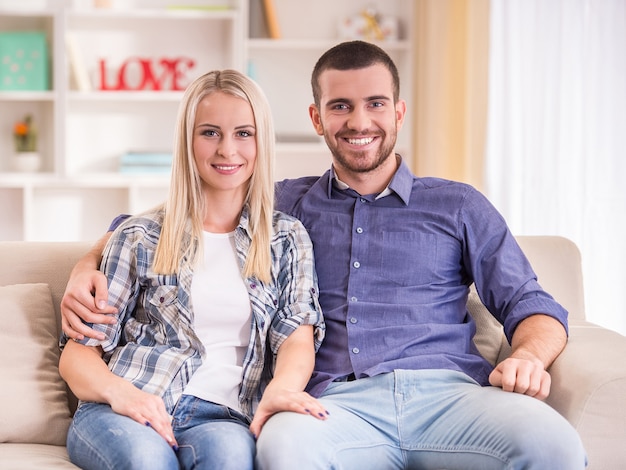 Loving young couple sitting on the couch at home.