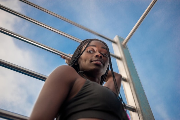 Low angle portrait of young woman against sky