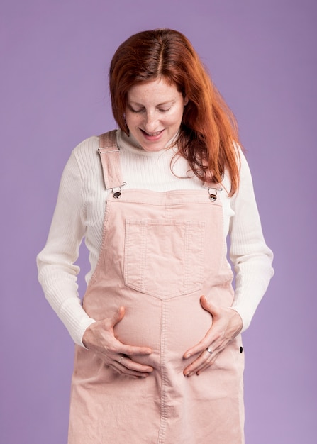 Low angle pregnant woman touching her belly