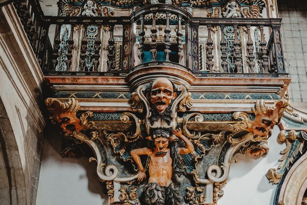 Low angle shot of an ancient building balcony decorated with a sculpture