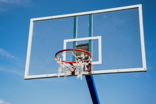 Low angle shot of a basketball basket under a blue sky