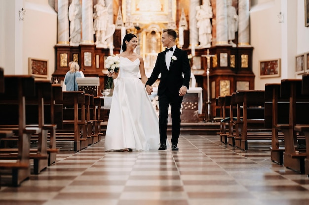 Low angle shot of a beautiful Caucasian white bride and groom together in the church in Lithuania