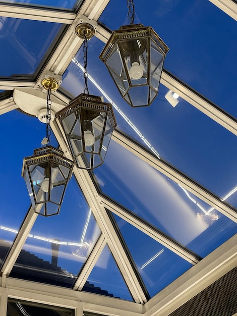 Low angle shot of beautiful vintage lantern lamps on glass windows ceiling