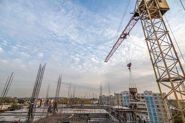 A low angle shot of a crane with equipment on a construction site near a new building infrastructure