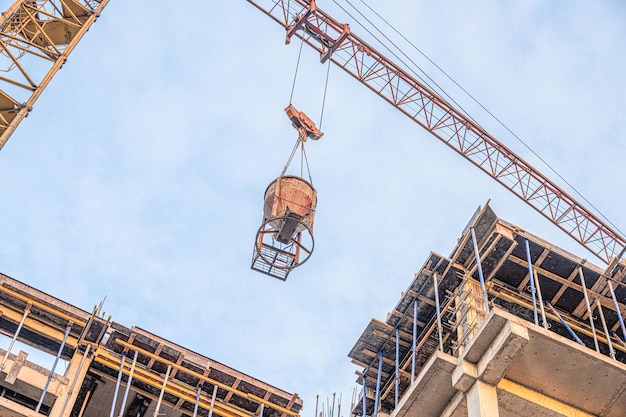 A low angle shot of a crane with equipment on a construction site with a new building infrastructure