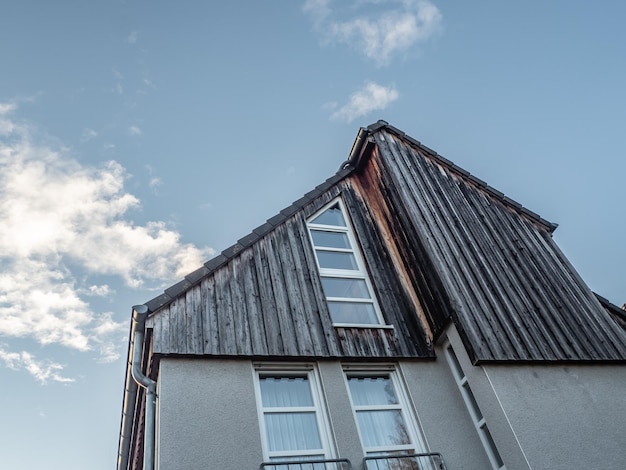 Low angle shot of a modern wooden house against a blue sky