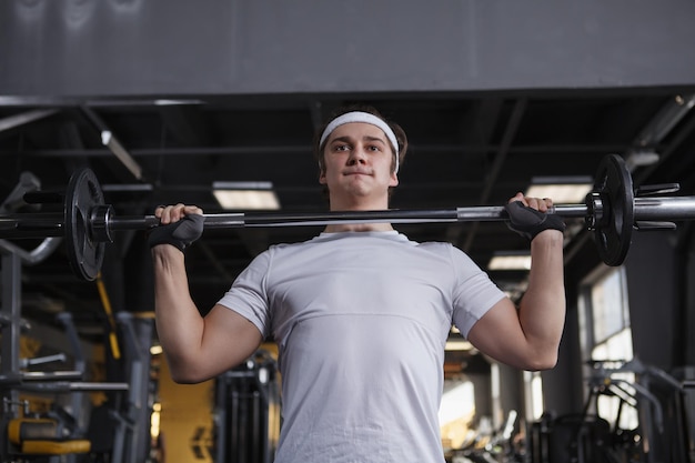 Low angle shot of a sportsman doing push press barbell exercise