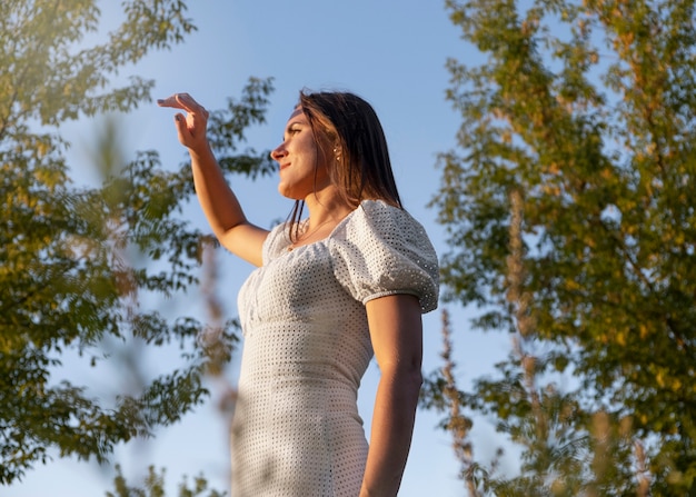 Low angle smiley woman enjoying nature