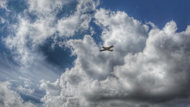 Low angle view of airplane flying against cloudy sky