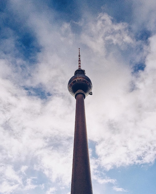 Photo low angle view of communications tower against cloudy sky