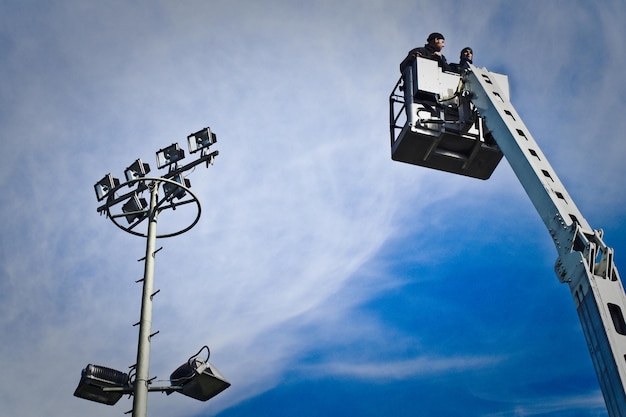 Photo low angle view of construction workers on cherry picker