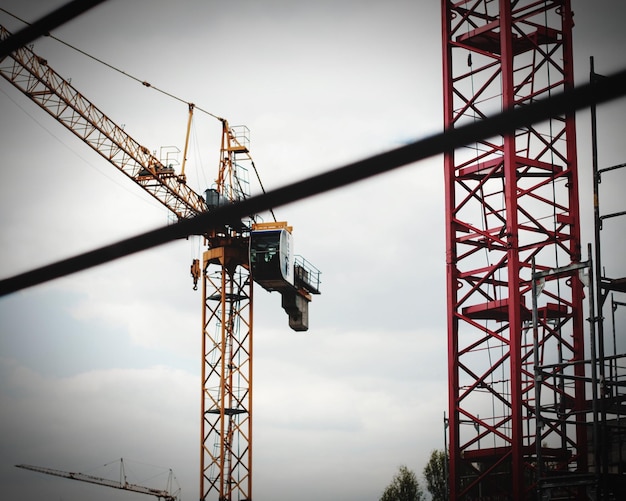 Photo low angle view of and cranes against sky