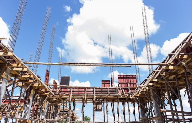 Low angle view of cranes at construction site against sky