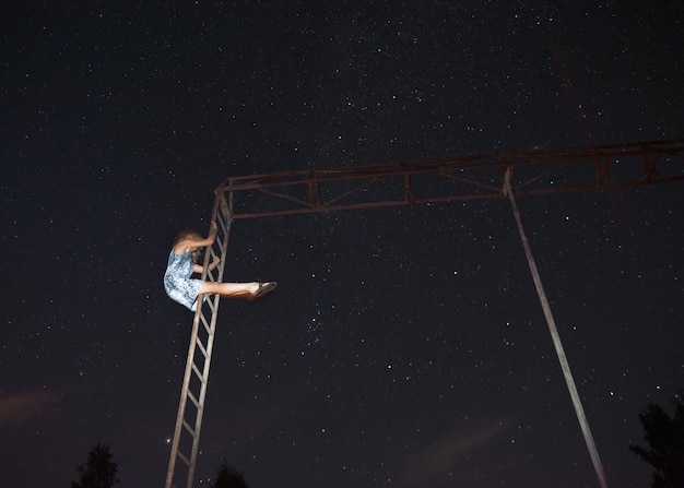 Low angle view of electric lamp against sky at night