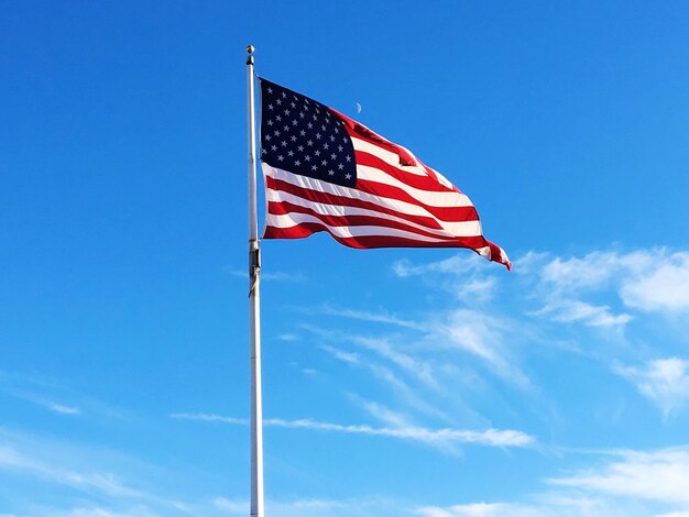 Low angle view of flag against blue sky