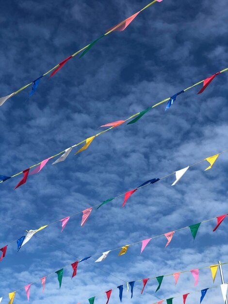 Low angle view of flags hanging against sky