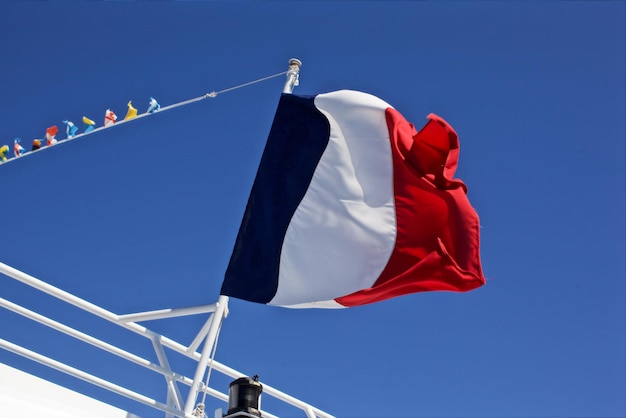 Photo low angle view of french flag on railing against clear blue sky