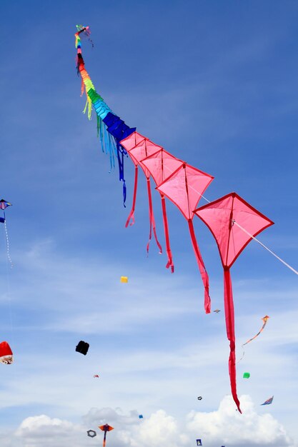 Low angle view of kites flying in blue sky