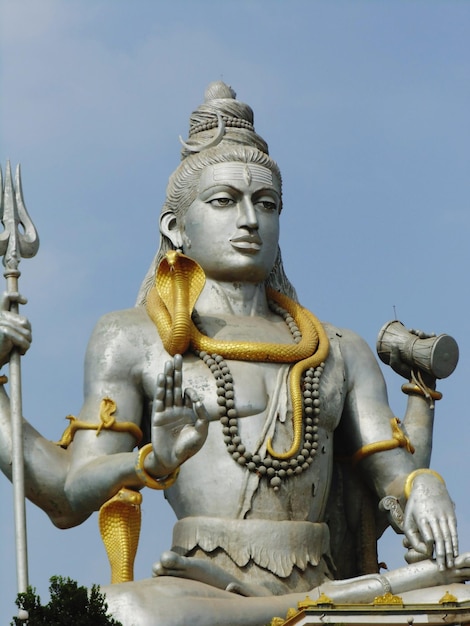 Low angle view of lord shiva statue against sky