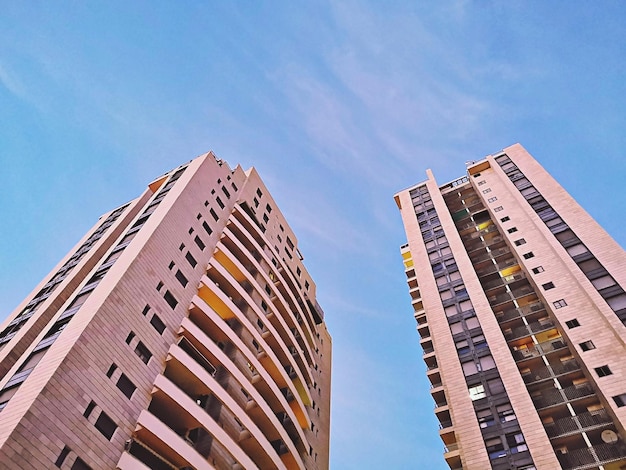 Low angle view of modern buildings against blue sky