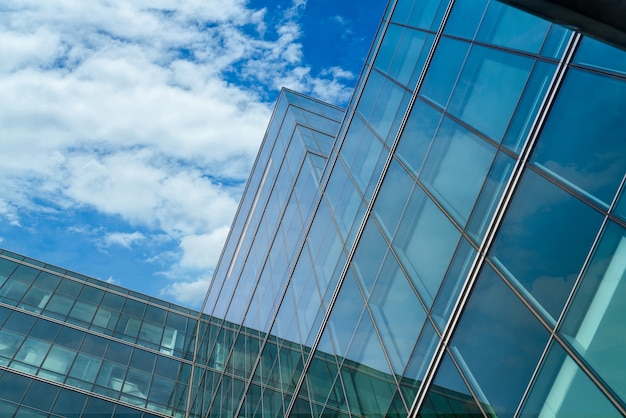 Low angle view of modern glass office building abstract background. Exterior office glass building architecture. Company glass window. Skyscraper corporate building. Financial business center tower.