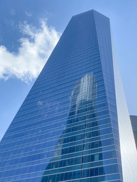 Low angle view of modern skyscraper Second building is reflected in the glass facade