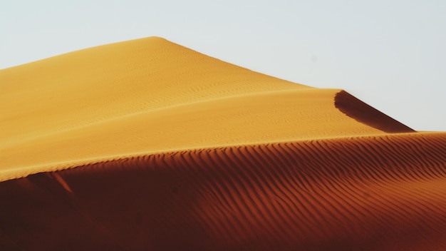 Photo low angle view of sand dunes against clear sky