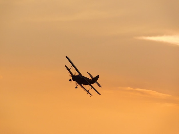 Low angle view of silhouette airplane against sky during sunset