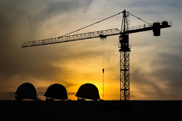 Low angle view of silhouette crane against sky during sunset