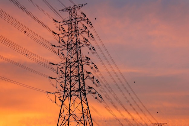 Low angle view of silhouette electricity pylon against romantic sky