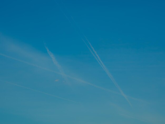 Low angle view of vapor trails against blue sky