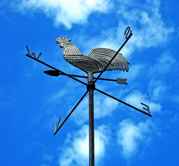 Photo low angle view of weather vane against blue sky