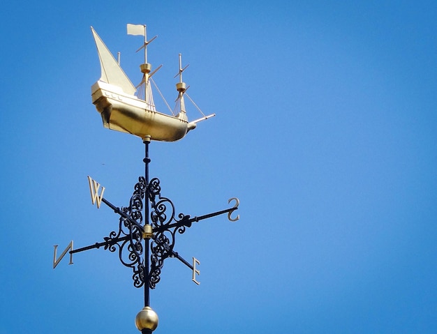 Photo low angle view of a weathervane against clear blue sky