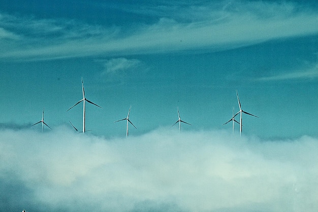 Low angle view of wind turbines against sky