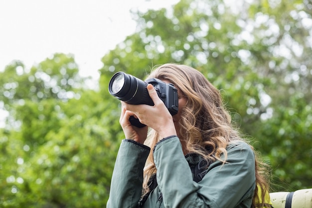 Low angle view of woman photographing with digital camera