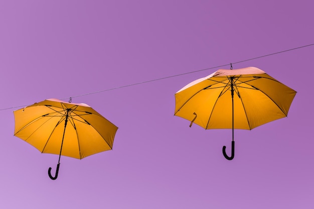 Low angle view of yellow umbrella against clear blue sky